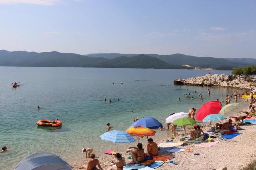 a group of people on a beach with umbrellas at Villa Mare in Klek