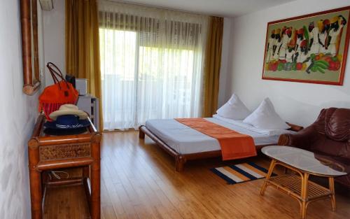 a bedroom with a bed and a couch and a table at Club Residence Apartments in Neptun
