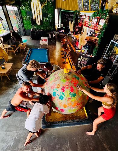 a group of people standing around a large globe at MBAR HOSTEL HAAD RIN in Haad Rin