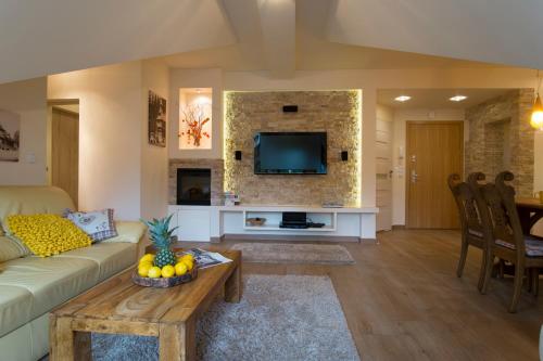 a living room with a couch and a tv at Apart-Center Pod Orłem in Zakopane