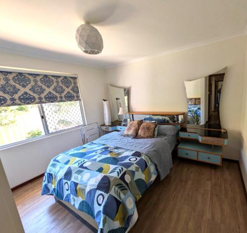 a bedroom with a bed and a large window at Ocean Drive Home: 3 bedroom 70s-inspired… - 19110 in Bunbury