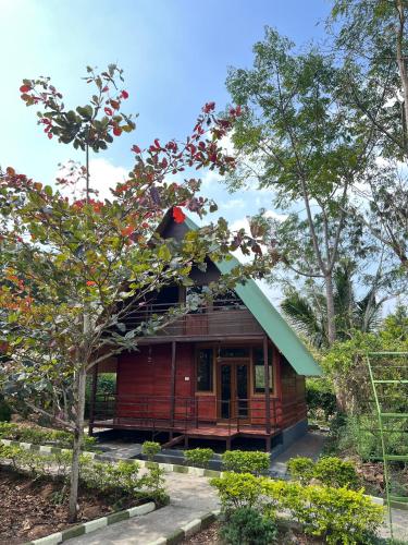 a small wooden house with a green roof at Jungle flare in Hampāpura