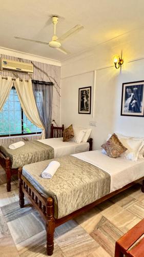 a bedroom with two beds and a window at Scarlets Inn in Cochin