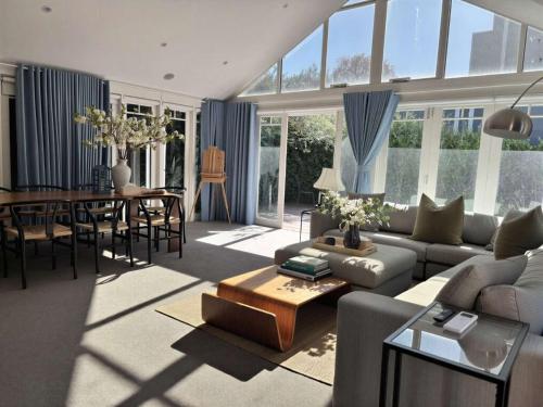 a living room with a couch and a table at Elegant Art Deco Gem Cosy 3BR Retreat in Carnegie
