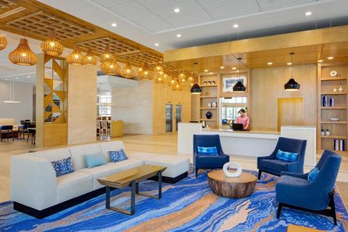 a lobby with a white couch and blue chairs at Hyatt House across from Universal Orlando Resort in Orlando