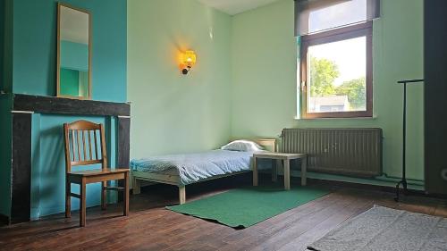 a bedroom with a bed and a chair and a window at Charlemagne house in Liège