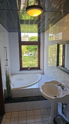 a bathroom with a tub and a sink and a window at Charlemagne house in Liège