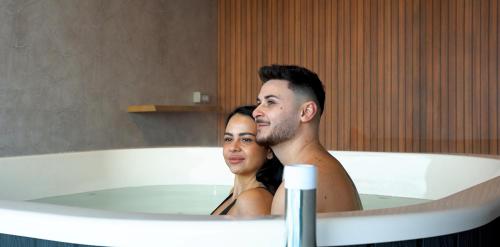 a man and a woman in a bath tub at Vila Hora cu Brazi in Zărneşti