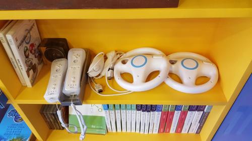 un estante con controladores de Nintendo Wii y consolas de juegos Nintendo Wii en Seri Inn Guesthouse en Busan