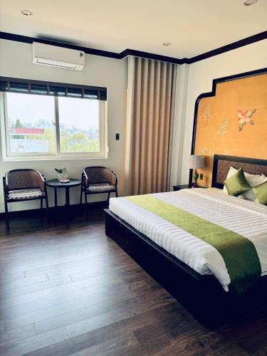 a bedroom with a large bed and a window at Biet Dien Hotel in Buon Ma Thuot