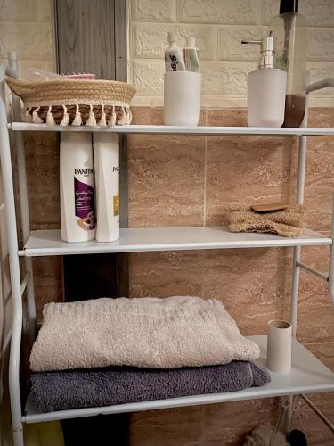 a shelf with towels and other items on it at Lozi House Cozy Stay in Al Azraq ash Shamālī