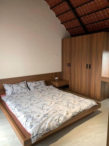 a bedroom with a large bed with wooden walls at The Little Home in Xuân Dục