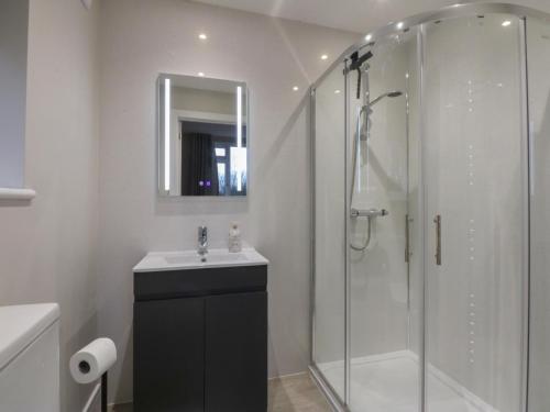 a bathroom with a shower and a sink and a toilet at Caledfryn in Benllech