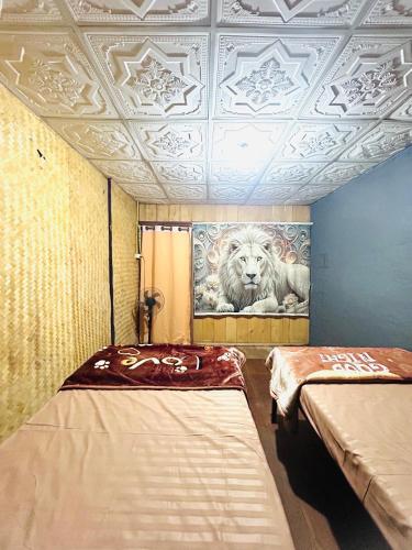 a room with two beds and a painting of a lion at Whatsup pai in Pai