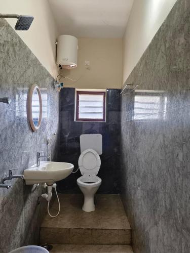 a bathroom with a toilet and a sink at RCH Home Stay in Rāmeswaram