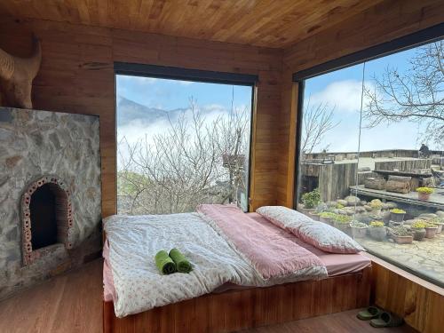 a bedroom with a bed and a large window at Cloud Garden in Bắc Yên