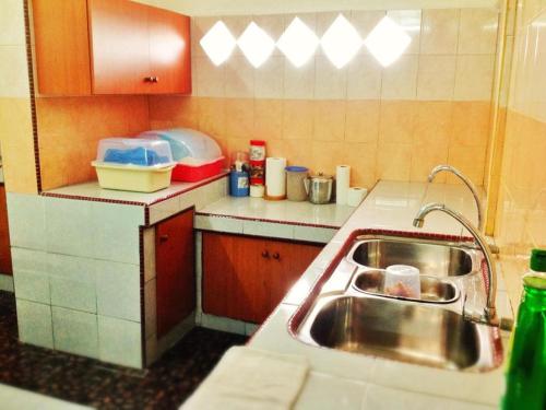 a kitchen with a sink and a counter top at Nur Muslim 2 Homestay At Kota Bharu in Kota Bharu