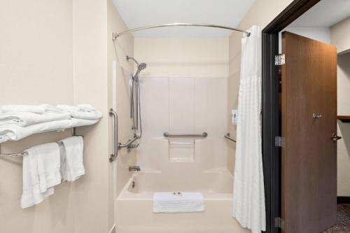 a bathroom with a tub and a shower with white towels at Comfort Inn Van Wert in Van Wert