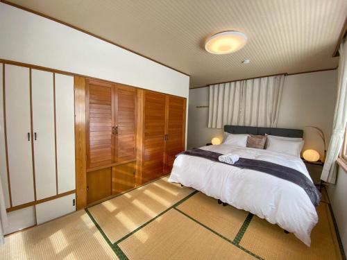 a bedroom with a large bed and wooden cabinets at KYŪKA Chalet in Myoko