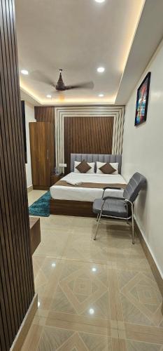 a bedroom with a bed and a chair in it at Hotel DC in Bacha