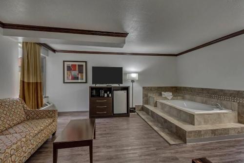 a large living room with a tub and a couch at Park Inn by Radisson, Salt Lake City-Midvale in Midvale