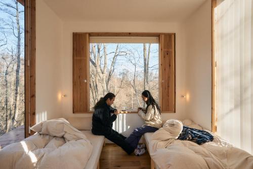 two women sitting on a couch in a room with a window at ist - Aokinodaira Field in Kawakami