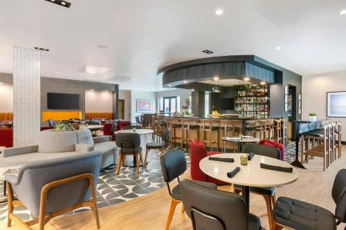 a restaurant with tables and chairs and a bar at Cambria Hotel Spokane Airport in Spokane