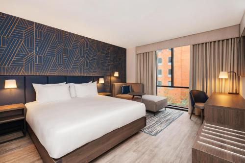 a hotel room with a bed and a desk at Hyatt Place Leeds in Leeds