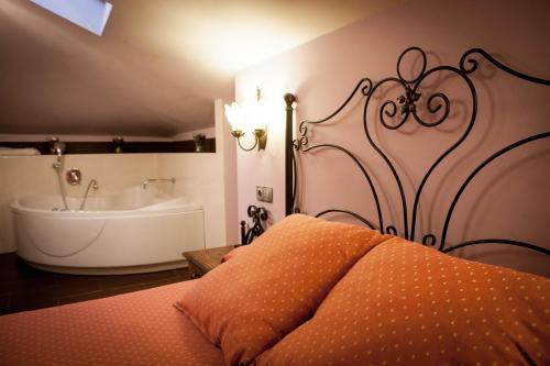 a bedroom with a tub and a bed with a bedspread at Pensión Ametzagaña in Donostia-San Sebastián