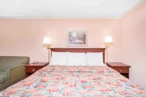Habitación de hotel con cama y silla en Knights Inn - Augusta, en Augusta