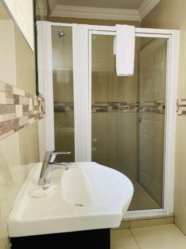 a bathroom with a sink and a shower at Bayside Hotel 97 Russell Street in Durban