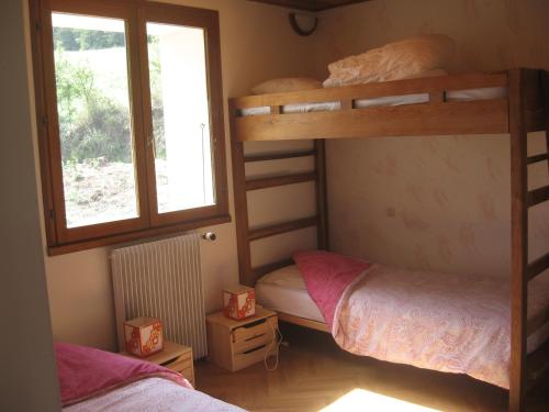 Saint-JeanにあるLes Elfesのベッドルーム1室(二段ベッド2台、窓付)が備わります。
