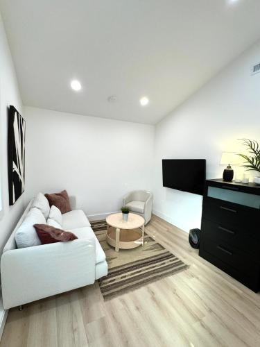 a living room with a white couch and a tv at Modern and Cozy Private Studio in Lynnwood