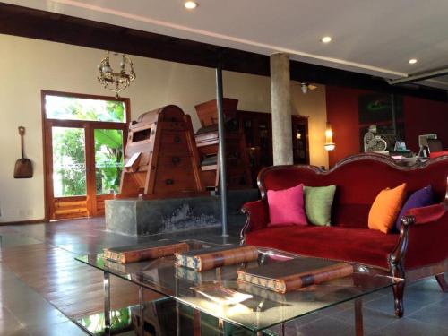 a living room with a red couch and a glass table at Hotel La Cautiva de Ramirez in La Paz