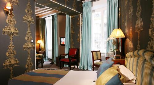 Una habitación de hotel con una cama y una ventana. en Hotel Résidence Des Arts - Saint-Germain, en París