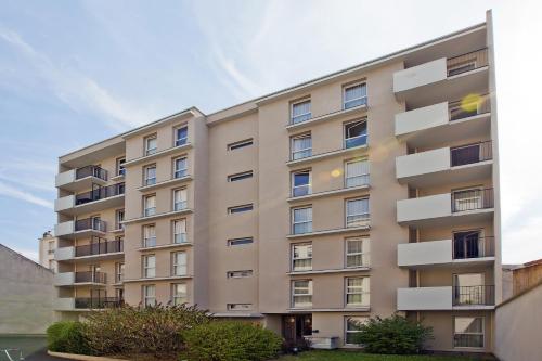 an apartment building with balconies on the side of it at Séjours & Affaires Paris-Malakoff in Malakoff