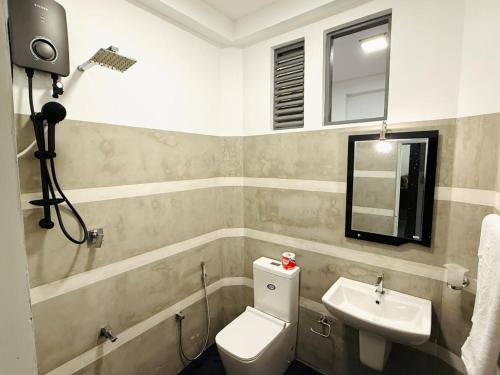 a bathroom with a sink and a toilet and a mirror at Roo Ceylon Beach Villa in Matara