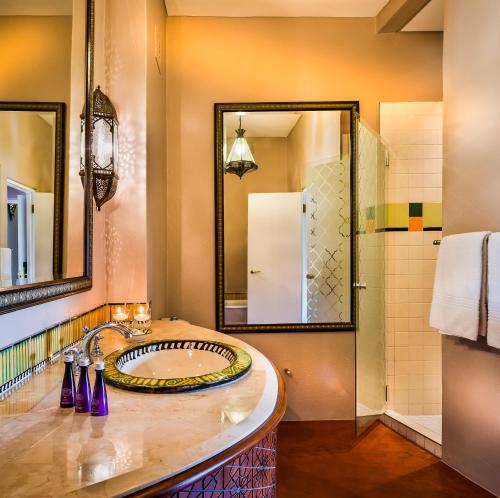 a bathroom with a sink and a shower at Avani Victoria Falls Resort in Livingstone