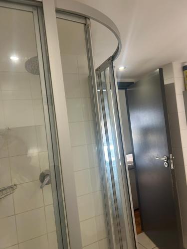 a shower with a glass door in a bathroom at 312 Mutual Heights Building in Cape Town