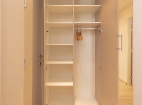 a walk in closet with white shelves at Appartement de Panne zeedijk in De Panne
