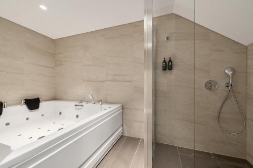 a bathroom with a white tub and a shower at Ramada by Wyndham Arnavutkoy in Istanbul