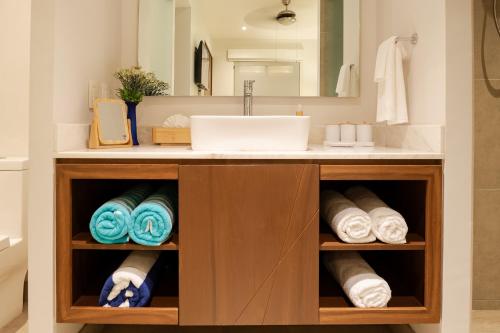 a bathroom vanity with a sink and towels at Pavilion 307 in Puerto Vallarta