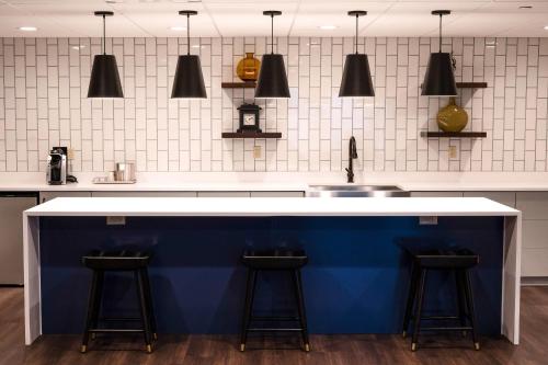a kitchen with a white and blue counter and stools at Galt House Hotel, A Trademark Collection Hotel in Louisville