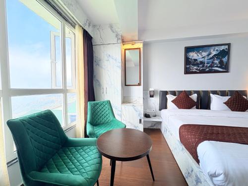 a hotel room with a bed and a table and chairs at Singalila Retreat by Barsana Group Darjeeling in Darjeeling