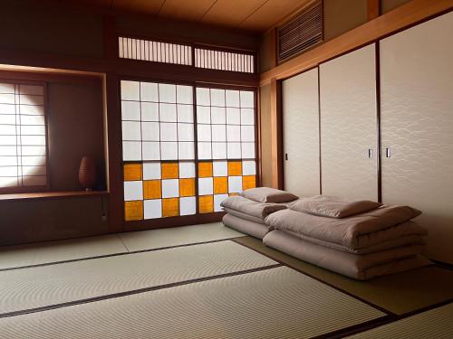 a room with a bed in a room with windows at Guest House WA in Kyoto