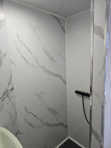 a bathroom with white marble walls and a shower at ArklesFCLiverpool in Liverpool