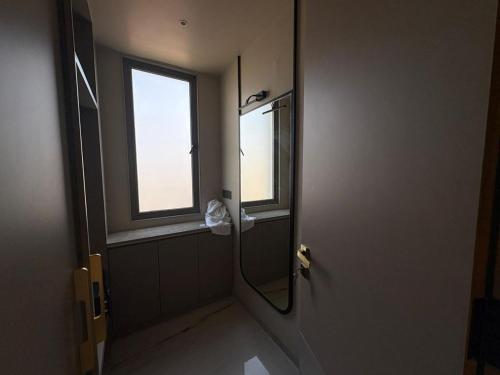 a bathroom with a shower with a mirror and a window at Dormstel - Unit of AHM Hotels & Resorts Pvt Ltd in Vadodara