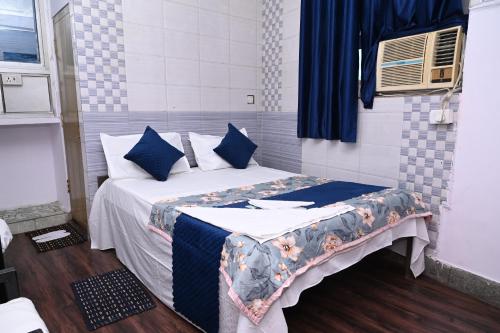a bedroom with a bed with blue pillows at Hotel Bluebell Inn in Lucknow