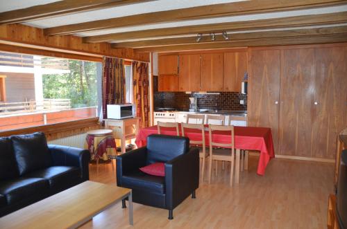 eine Küche und ein Esszimmer mit einem roten Tisch und Stühlen in der Unterkunft Immeuble Les Aiglons in Les Collons