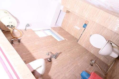 a bathroom with a toilet and two sinks in it at Hotel Bluebell Inn in Lucknow